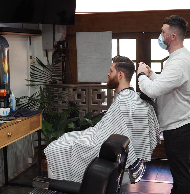 Hairdresser and client in chair at Carnegie barbershop